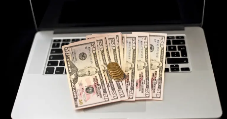 A pile of dollars on a laptop