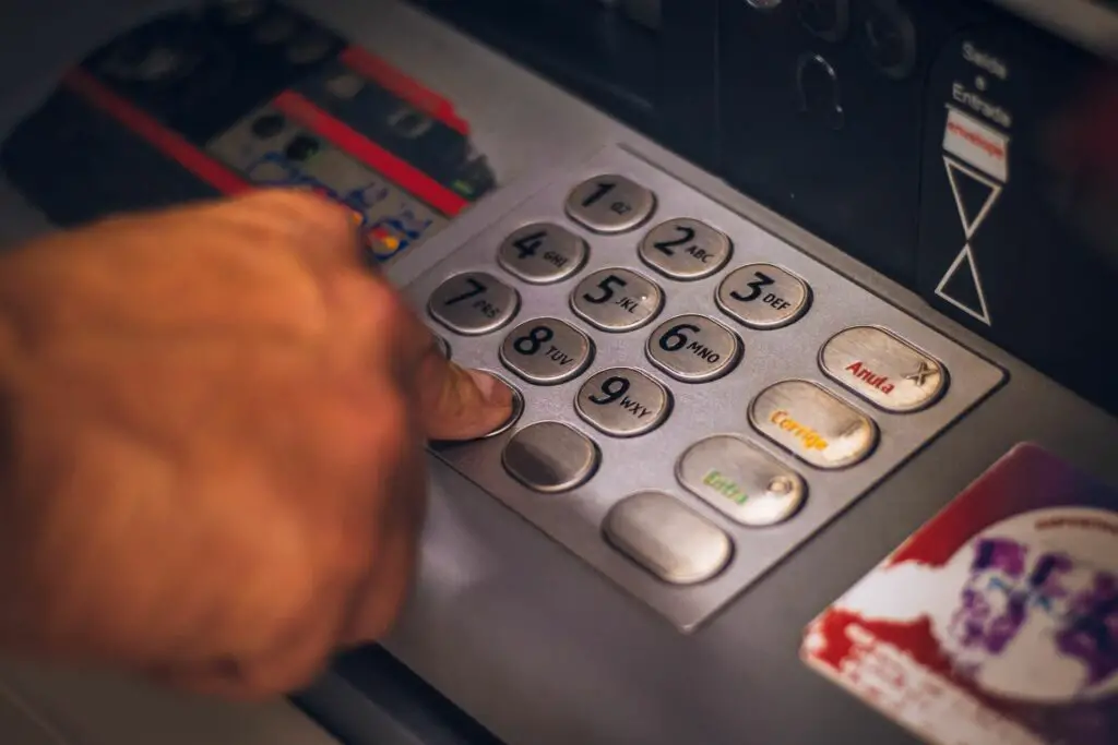 A man using buttons on an ATM