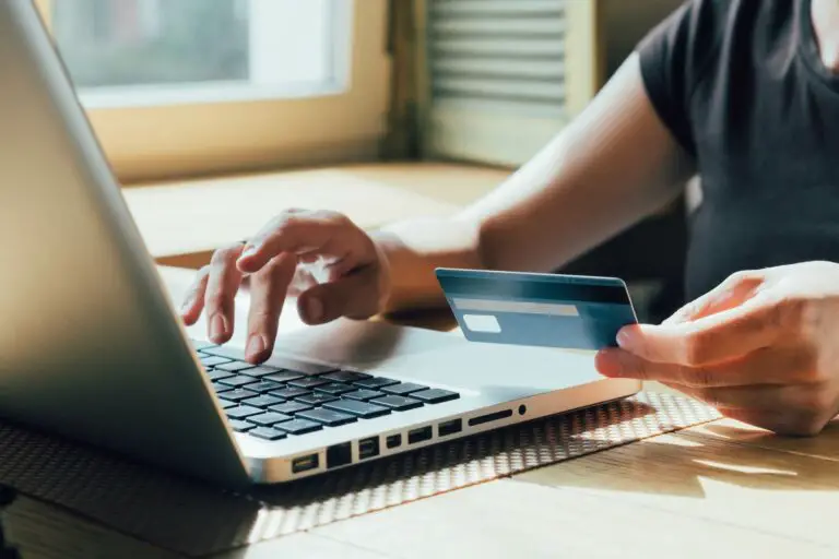 Person using a debit card and a laptop