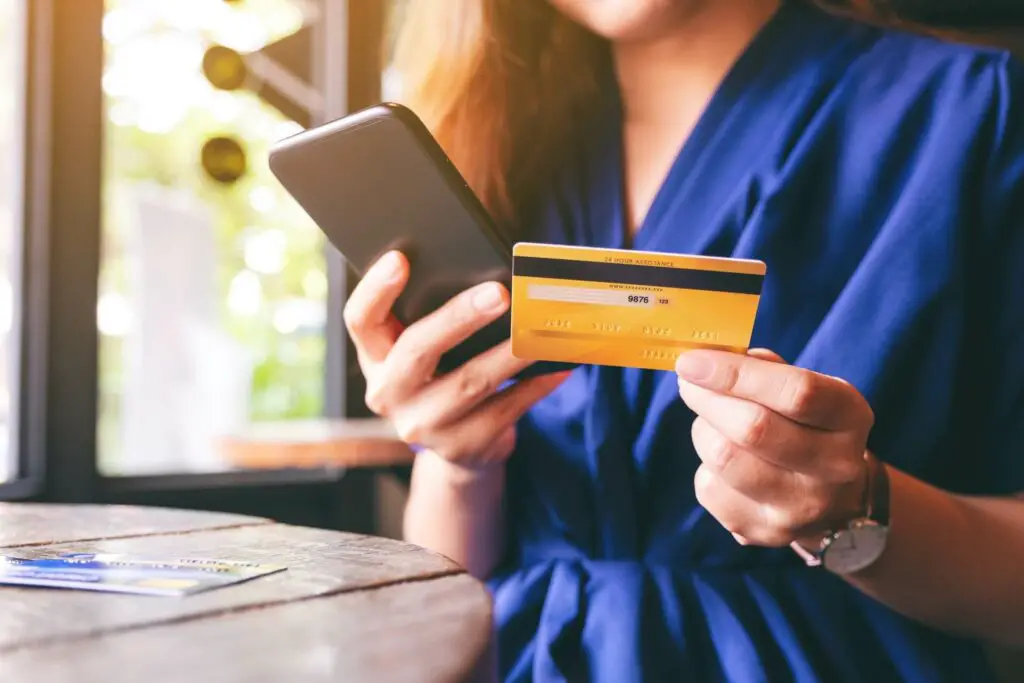 Woman holding a credit card and a phone