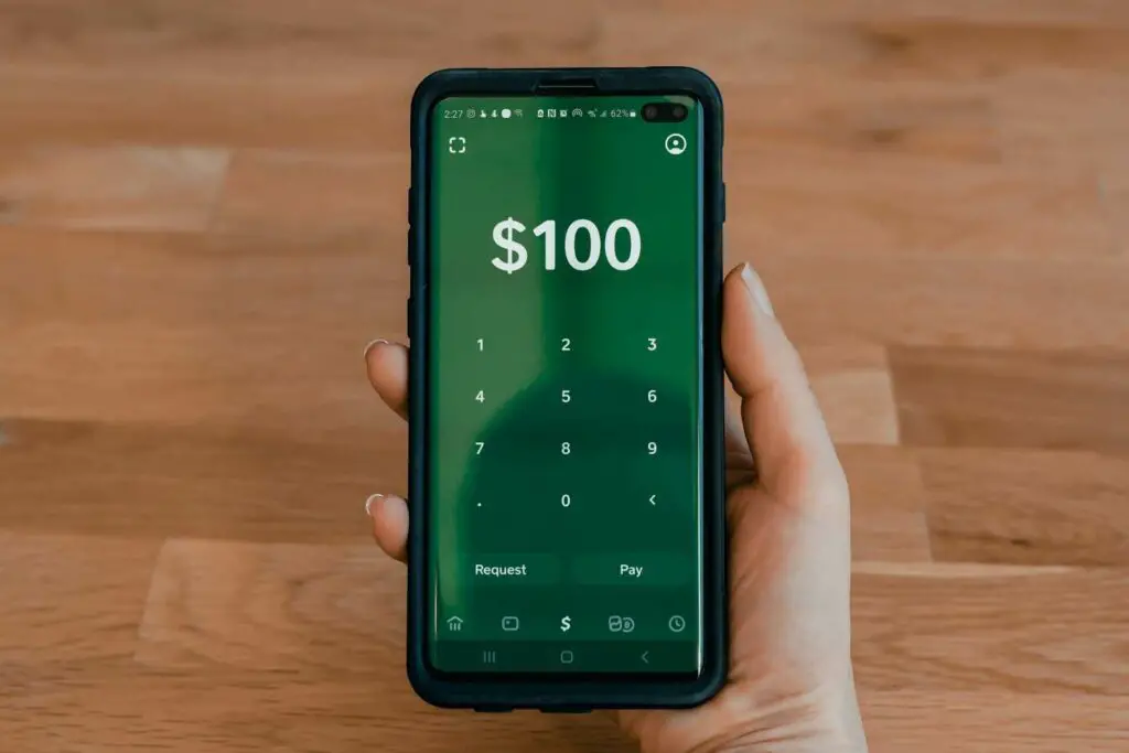 Person holding a phone displaying a Cash App balance