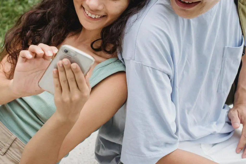 Woman sitting with a man and holding a phone