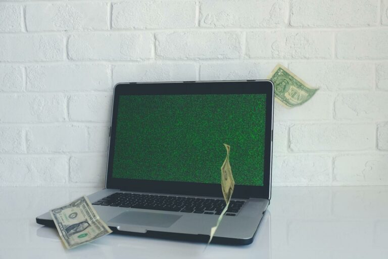An image of a hacked computer with green code and bills flying around