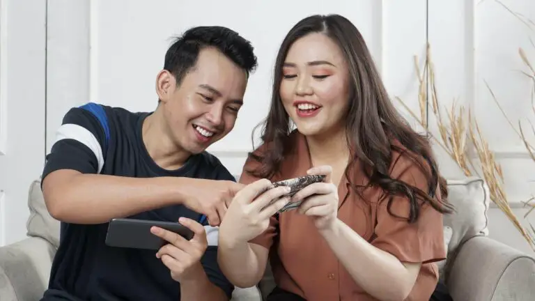 Two people holding phones and smiling