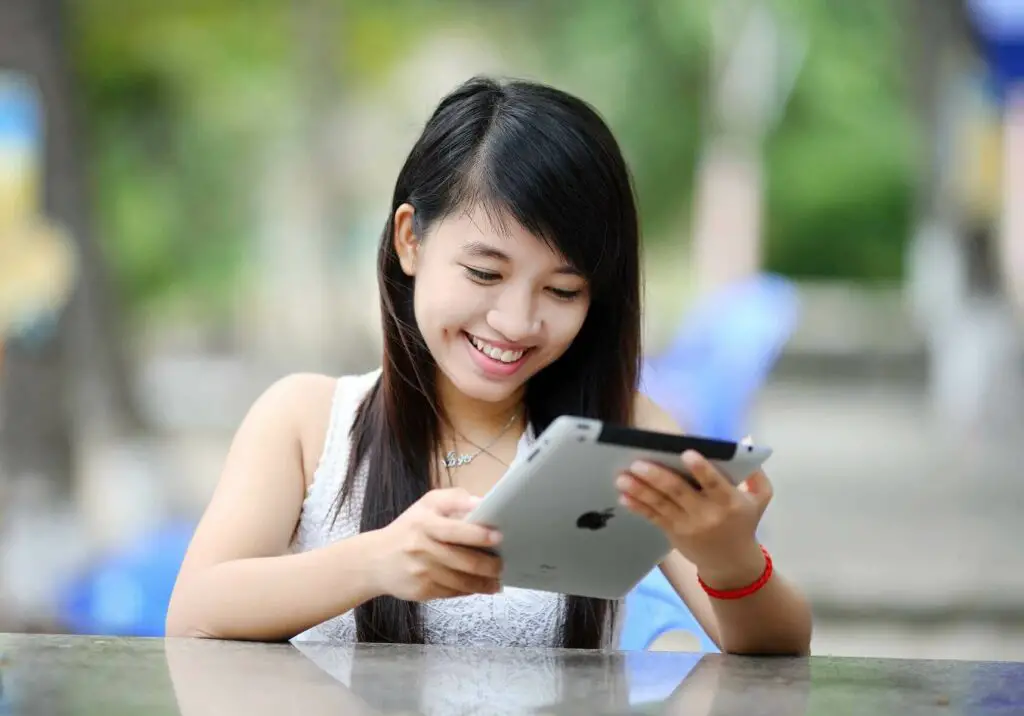 Young woman holding a tablet and smiling