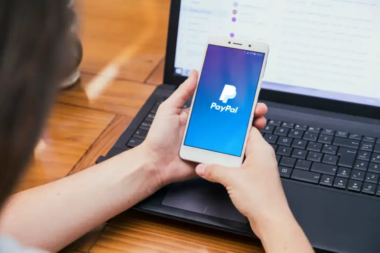 Woman looking at PayPal logo on her phone
