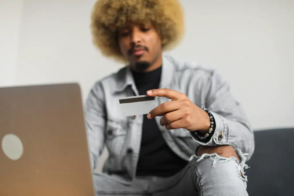 Man with afro hair holding a credit card